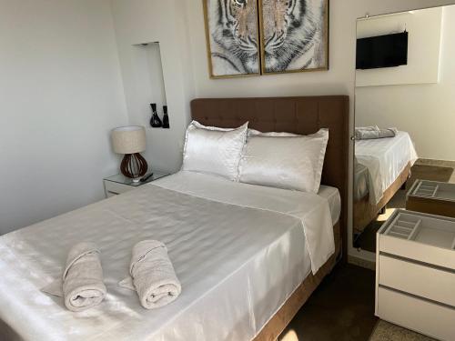 a bedroom with a white bed with towels on it at Apart Hotel Seg Total Lofts Encantadores in Mogi-Guaçu