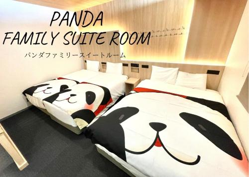 two beds in a room with a panda family suite room at Henn na Hotel Tokyo Asakusa Tawaramachi in Tokyo