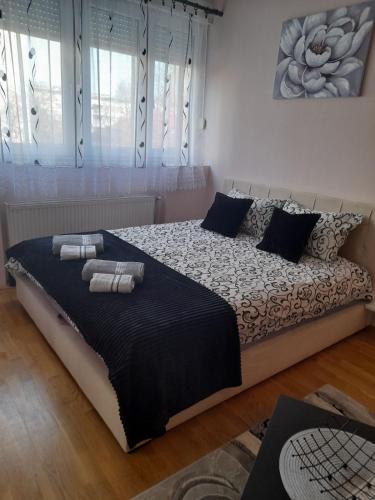 Un dormitorio con una cama grande con dos toallas encima. en Apartman Aurora, en Novi Sad