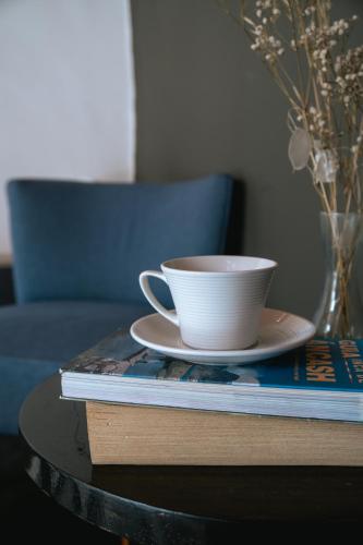 a cup of coffee sitting on a table with a book at The Lot Boutique in Lima