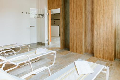 a room with tables and chairs and a hallway at Rosenalm Scheidegg in Scheidegg