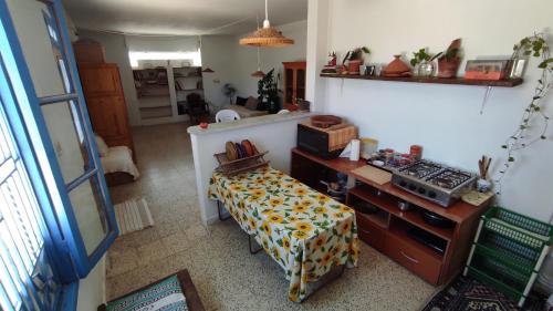 Zimmer mit einem Tisch und einer Küche. in der Unterkunft Charmant logement avec jardin en permaculture in Chebba