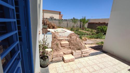 un jardín con una pared de piedra en un patio en Charmant logement avec jardin en permaculture en Chebba