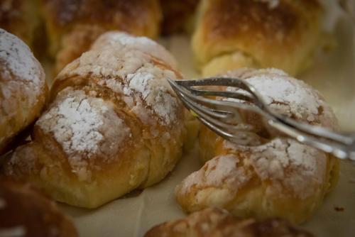 a fork in a pile of doughnuts with powdered sugar at Berghotel in Bergamo