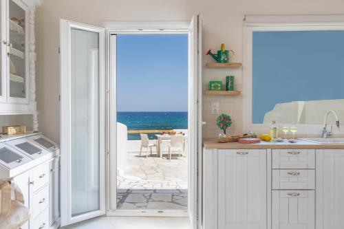 a kitchen with a door leading to the ocean at Ma mer in Naxos Chora