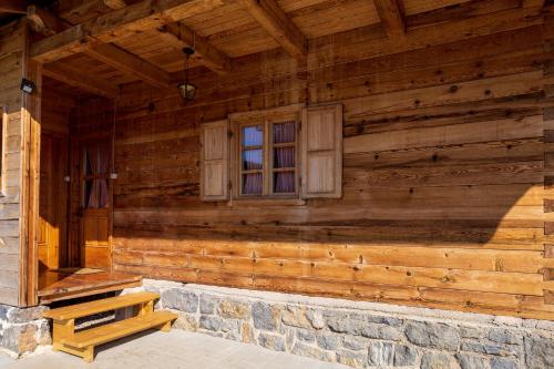 a wooden house with a window and a stone step at Kuća za odmor Lara in Otočac