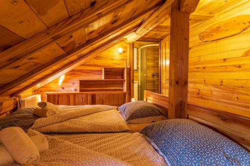a bedroom with two beds in a log cabin at Kuća za odmor Lara in Otočac