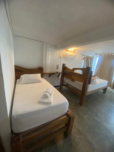 a small bedroom with two beds and a window at Mamallena Beachside Rincon del Mar in Rincón