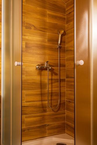 a shower with a hose in a wooden wall at Kuća za odmor Lara in Otočac