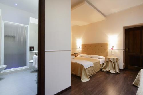 a bedroom with a bed and a bathroom at Caesar Place in Rome