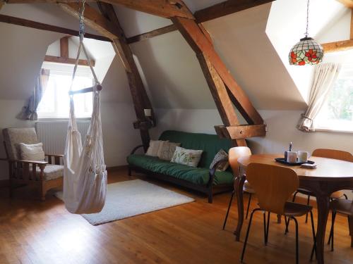 een woonkamer met een tafel en een groene bank bij Les Vergers de Cussy in Cussy-en-Morvan