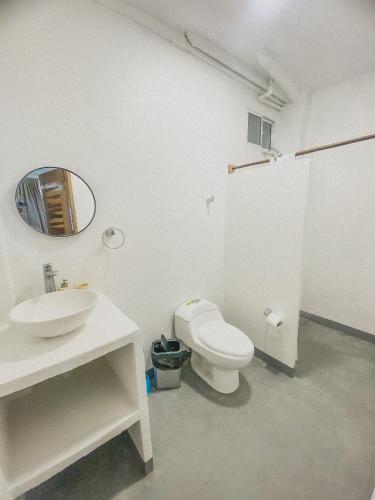 a bathroom with a toilet and a sink and a mirror at Mamallena Beachside Rincon del Mar in Rincón