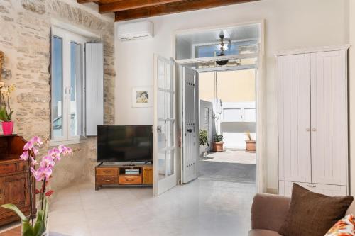 a living room with a television and an open door at Ma mer in Naxos Chora