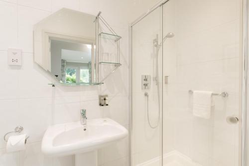 a white bathroom with a sink and a shower at Willowbeck Lodge Boutique Hotel in Carlisle
