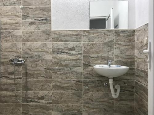 een badkamer met een wastafel en een spiegel bij Lesnovo House Tomevski in Lesnovo
