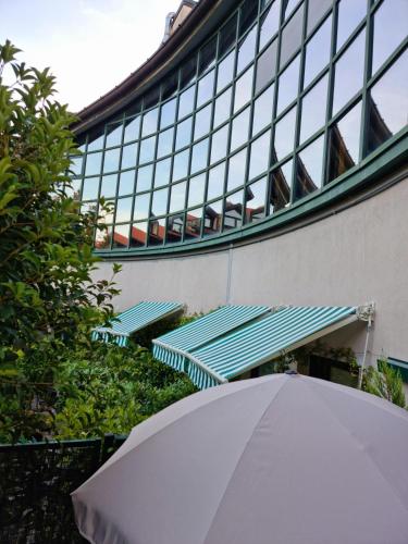 a white umbrella sitting in front of a building at Victoria Royal Garden in Como