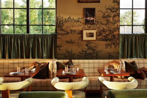 a restaurant with two tables and chairs and windows at Life House, Berkshires in Lenox