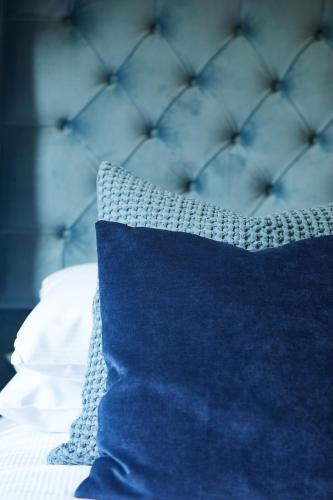 a blue pillow sitting on top of a bed at Willowbeck Lodge Boutique Hotel in Carlisle