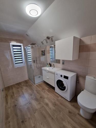 a bathroom with a toilet and a washing machine at Zacisze na Roztoczu in Horyniec