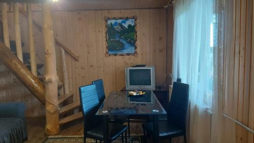 Un comedor con una mesa con una computadora encima. en Дімона, en Mykulychyn