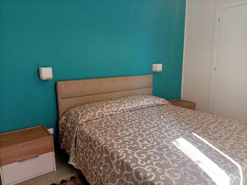 a bedroom with a bed and a blue wall at A casa di Maria in Marsala