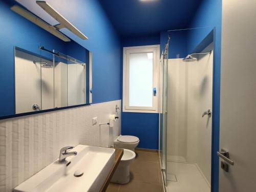a blue bathroom with a sink and a toilet at A casa di Maria in Marsala