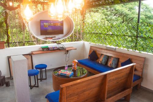 eine abgeschirmte Veranda mit einem Sofa und einem TV in der Unterkunft Jugglers Backpack in Pune