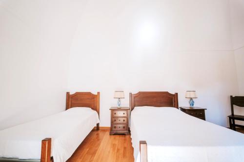 two beds sitting next to each other in a bedroom at O Conventinho in Évora