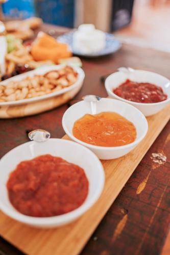 a wooden table topped with bowls of sauce and other food at O Conventinho in Évora