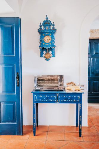 a blue table with a clock on a wall at O Conventinho in Évora