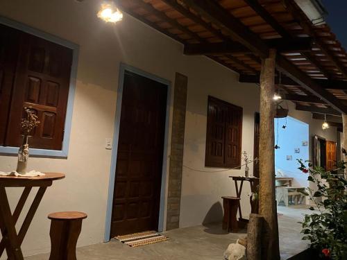 Habitación con puerta, mesa y sillas en Pousada Casa de Naue - Ilha de Boipeba, en Isla de Boipeba