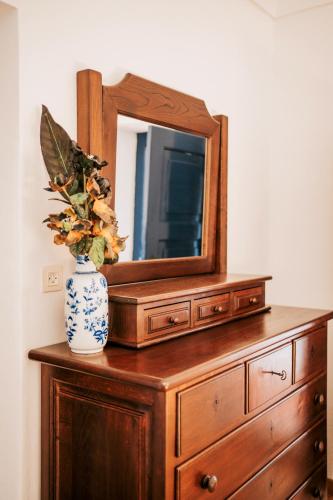 a dresser with a mirror and a vase on it at O Conventinho in Évora