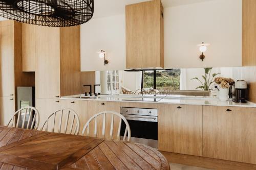 a kitchen with wooden cabinets and a table with chairs at ALDAPA Casa Rural in Laguardia