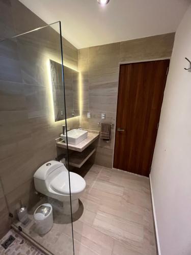 a bathroom with a toilet and a sink and a mirror at Nuevo 3R 3B 1E Club Playa Gratis Tenis Padel Diamante Albercas in Acapulco