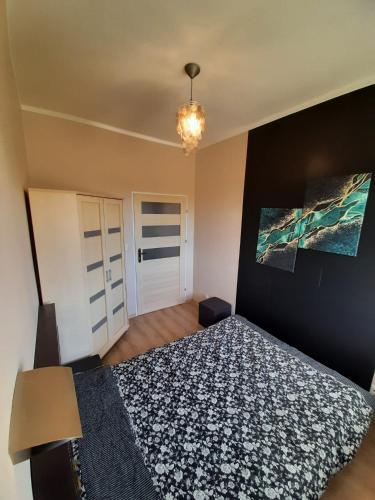 sypialnia z łóżkiem i obrazem na ścianie w obiekcie Apartament Kaszownik w Toruniu