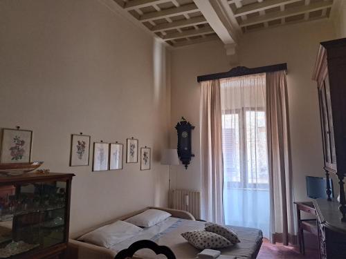 a bedroom with a bed and a window at Finestra Dell'Angelo in Pienza