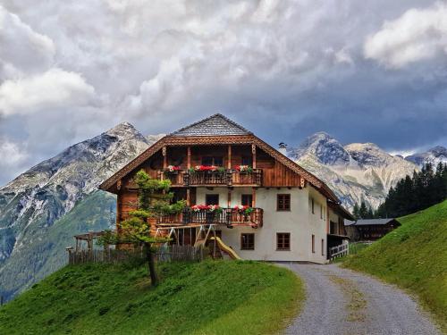 a house on a hill with flowers on a balcony at Bichlhof in Kaisers