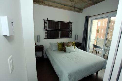 魁北克市的住宿－Condo "Imagine" - stationnement privé inclus，卧室配有白色的床和窗户。