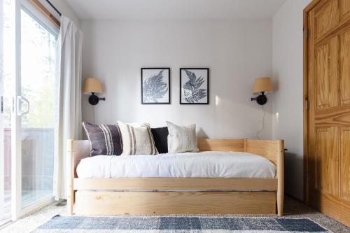 1 dormitorio con 1 cama con sábanas y almohadas blancas en Jumper By AvantStay Serene Stylish Cabin w Hot Tub, en Big Bear Lake