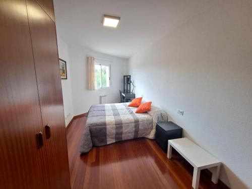 a bedroom with a bed with orange pillows on it at Apartamento con vistas, amplio y luminoso in Monforte de Lemos