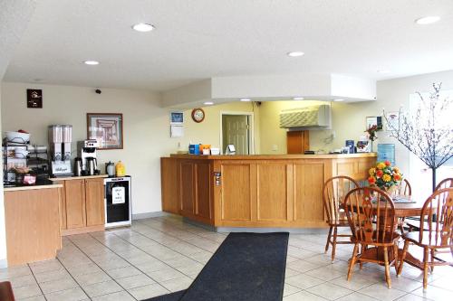 a large kitchen with wooden cabinets and a table at Tel Star Motel in Brooks