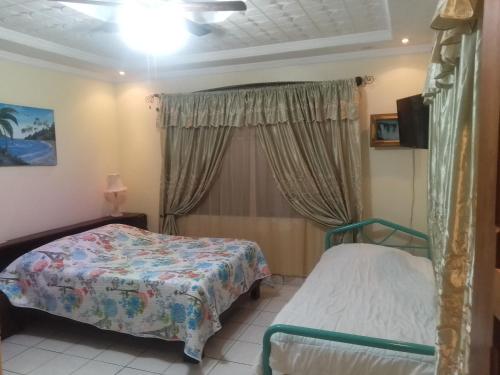 um quarto com 2 camas e uma janela em Alexander b&b em Alajuela
