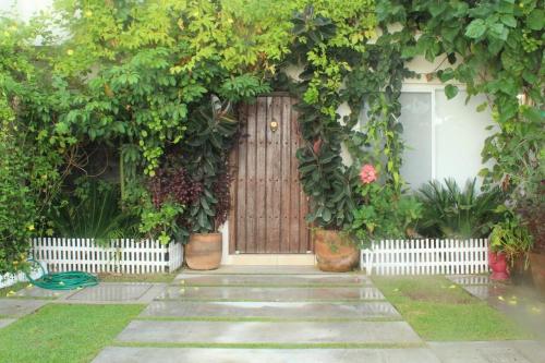 een voordeur van een huis met een bos planten bij Hacienda en Primavera, descanso Familiar total in Puerto Vallarta