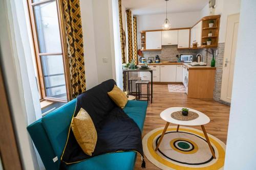 un salon avec un canapé bleu et une table dans l'établissement Au petit moulin, plein centre ville Montbéliard, à Montbéliard