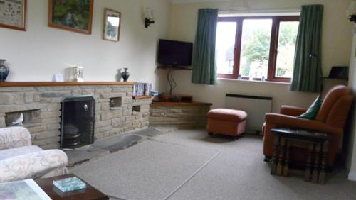 sala de estar con sofá y chimenea en Bramley Cottage Holidays, en Chichester