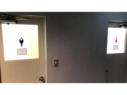 a bathroom with two mirrors and a door with a person on it at Kagetsu Ryokan - Vacation STAY 04876v in Shizuoka