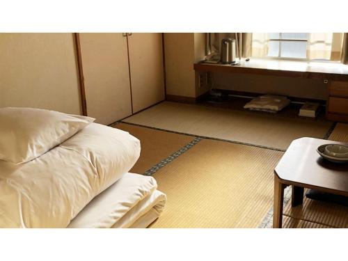 a room with a bed and a table and a window at Kagetsu Ryokan - Vacation STAY 04023v in Shizuoka