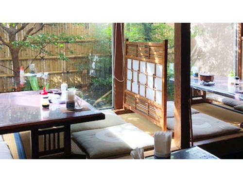 a room with a table and chairs and a window at Kagetsu Ryokan - Vacation STAY 04023v in Shizuoka