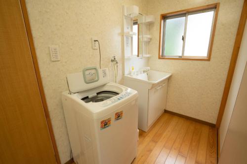 een kleine badkamer met een wasmachine en een wastafel bij I,K,I HOUSE SAIDOFURE - Vacation STAY 14778v in Iki