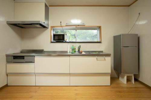 uma cozinha com um lavatório e um frigorífico em I,K,I HOUSE SAIDOFURE - Vacation STAY 14778v em Iki